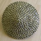 ceramic sculpture of geometric sphere smooth green one side spiked green other side